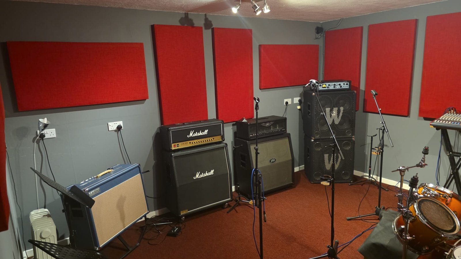 A real Smashroom rehearsal room in Ketley with Marshall amplifier stacks, a drum kit and red acoustic panels, set up and ready